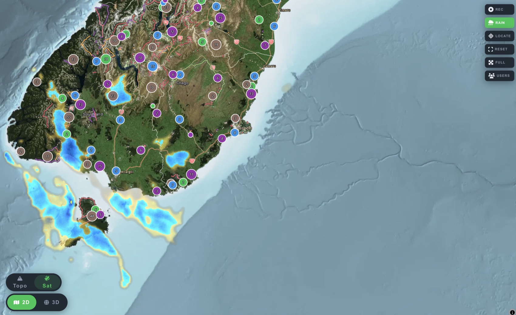 Live rain radar over Southland and Stewart Island, showers tracking across Foveaux Strait, with campsites and huts marked across Otago and Fiordland.